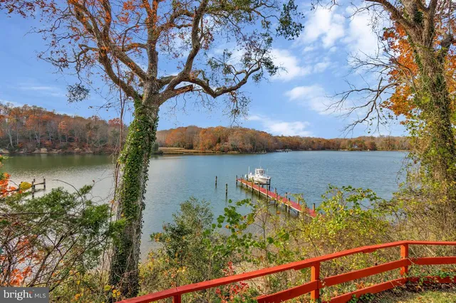 an aerial view of residential houses with outdoor space and lake view