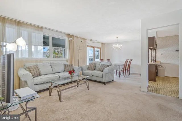 a bedroom with a bed a flat screen tv and a chandelier