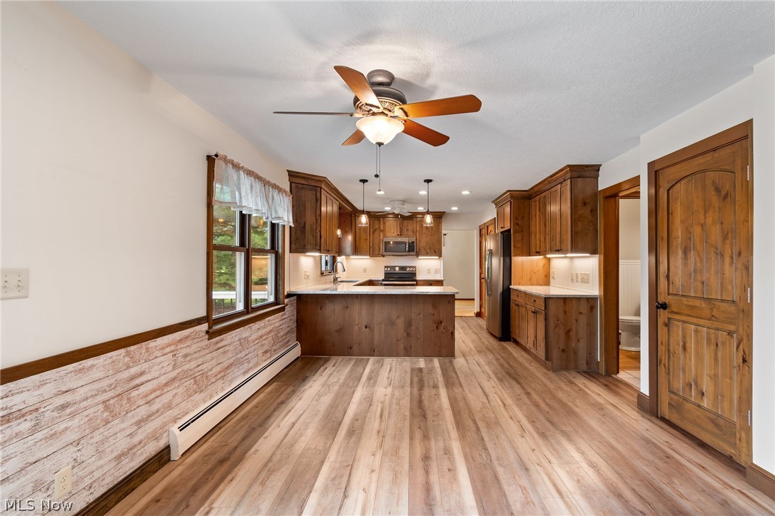 34 Kehner Road Mogadore, OH 44260 - Photo 9 of 40 Full kitchen featuring wood cabinetry, stainless steel appliances, and an island with seating