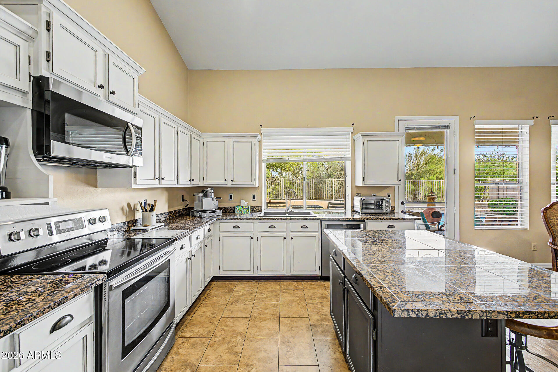 4309 East Rancho Caliente Drive Cave Creek, AZ 85331 - Photo 12 of 37 a kitchen with granite countertop a sink stove top oven and microwave