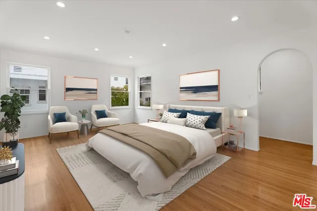 a spacious bedroom with a large bed and windows