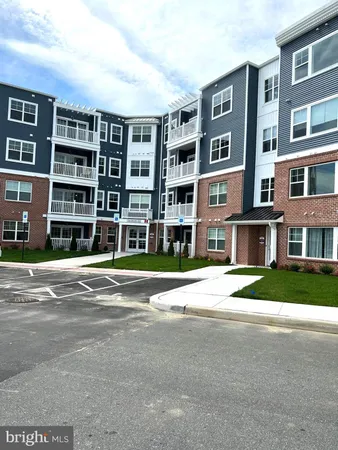 a kitchen with granite countertop a stove a sink and a refrigerator