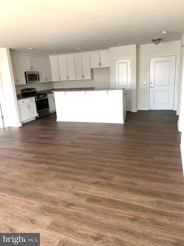 a kitchen with stainless steel appliances granite countertop a stove a sink and white cabinets