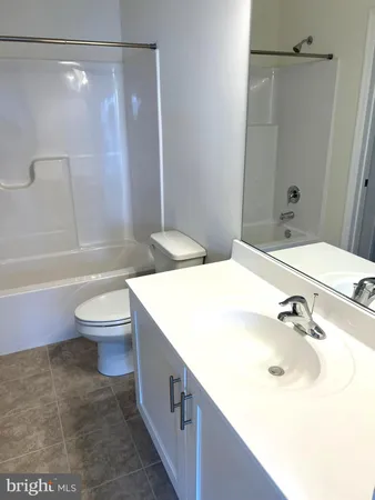 a bathroom with a granite countertop sink toilet a mirror and shower