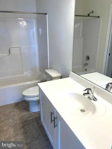 a bathroom with a granite countertop sink toilet a mirror and shower