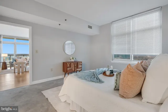 a bedroom with a large bed and a chandelier