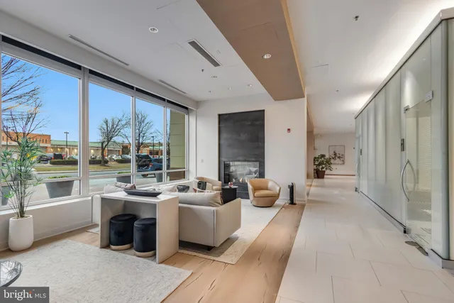 a large white room with stainless steel appliances kitchen island granite countertop a large window and a view of living room