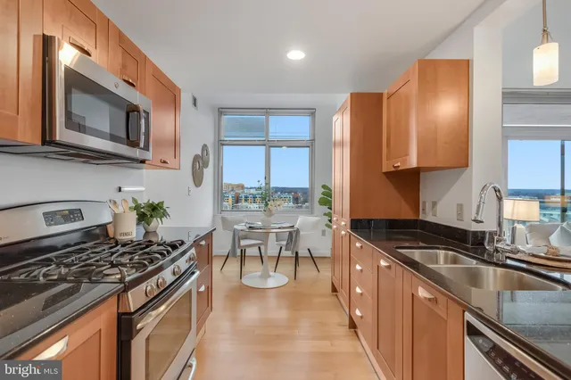 a kitchen with stainless steel appliances granite countertop a sink stove and microwave