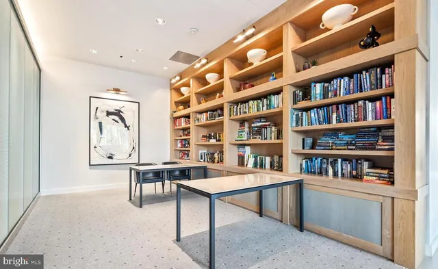 a reading room with furniture book shelf and a window