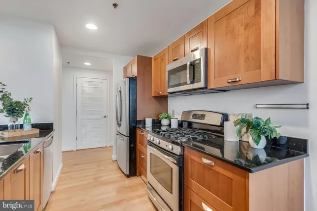 a kitchen with stainless steel appliances granite countertop a stove a sink and a refrigerator