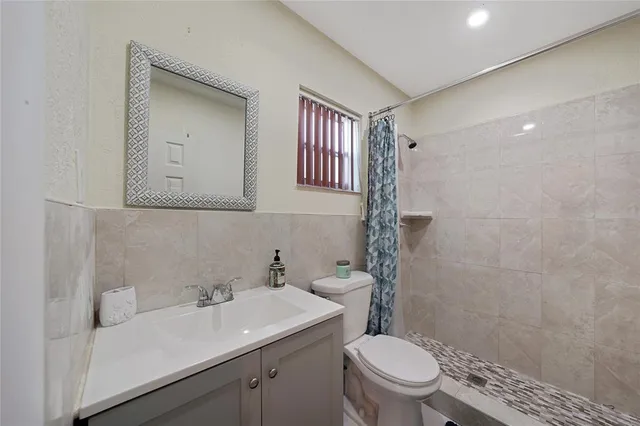 a bathroom with a toilet a sink and mirror