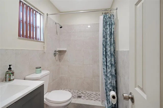 a bathroom with a shower a toilet and a sink