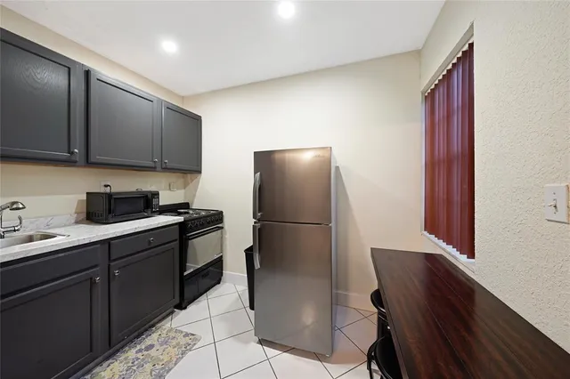 a kitchen with a sink a refrigerator and cabinets