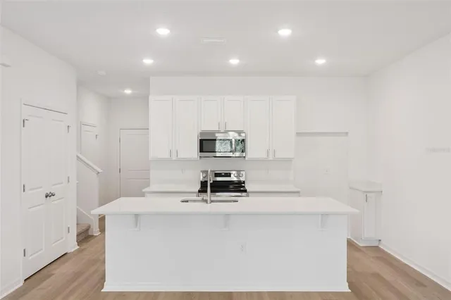 a kitchen with kitchen island a sink a stove and a refrigerator