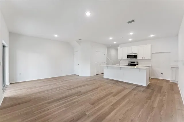 a view of kitchen with granite countertop cabinets and refrigerator