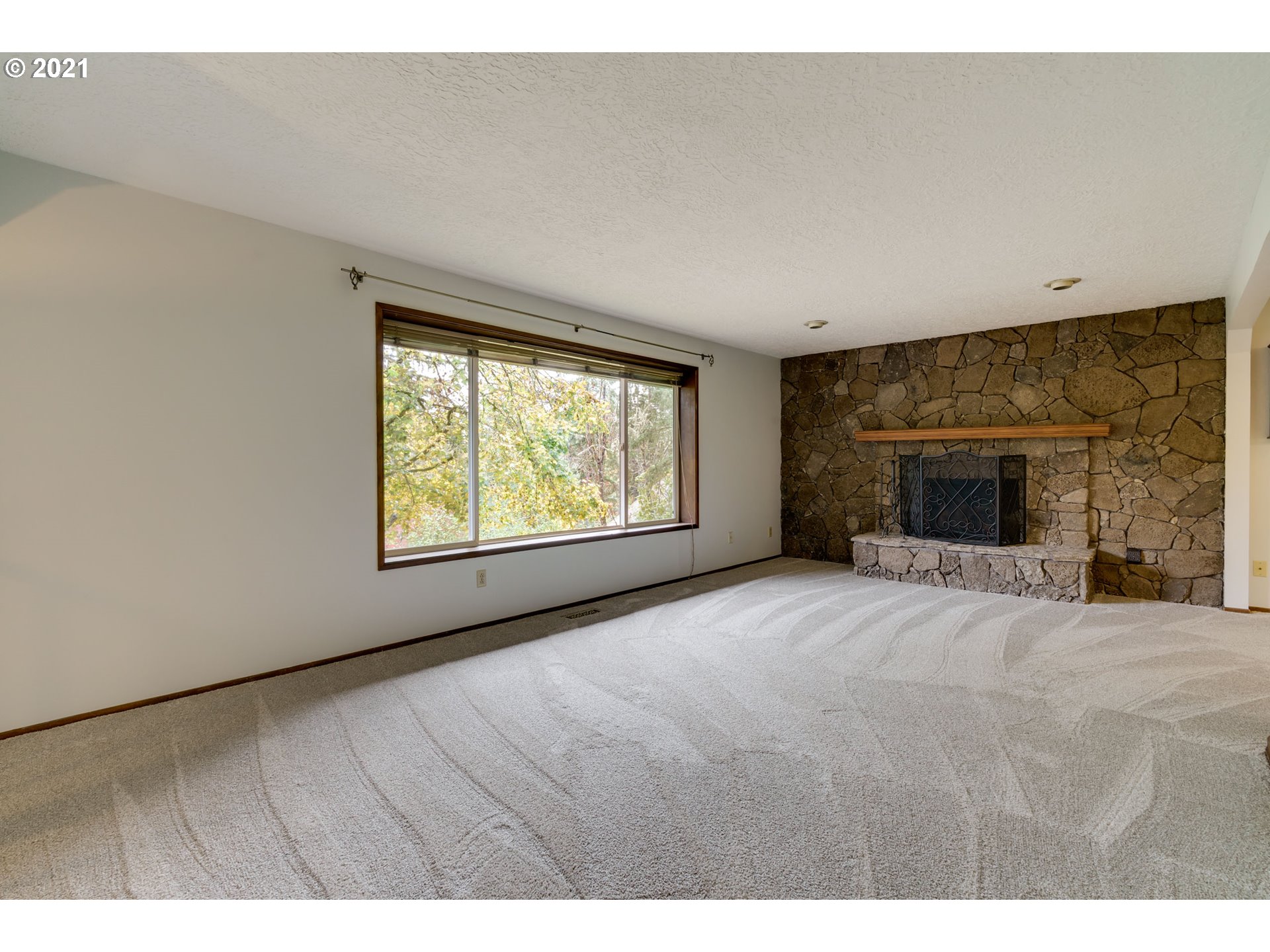 17201 Southeast Tong Road Damascus, OR 97089 - Photo 4 of 21 a view of an empty room with a window and fireplace