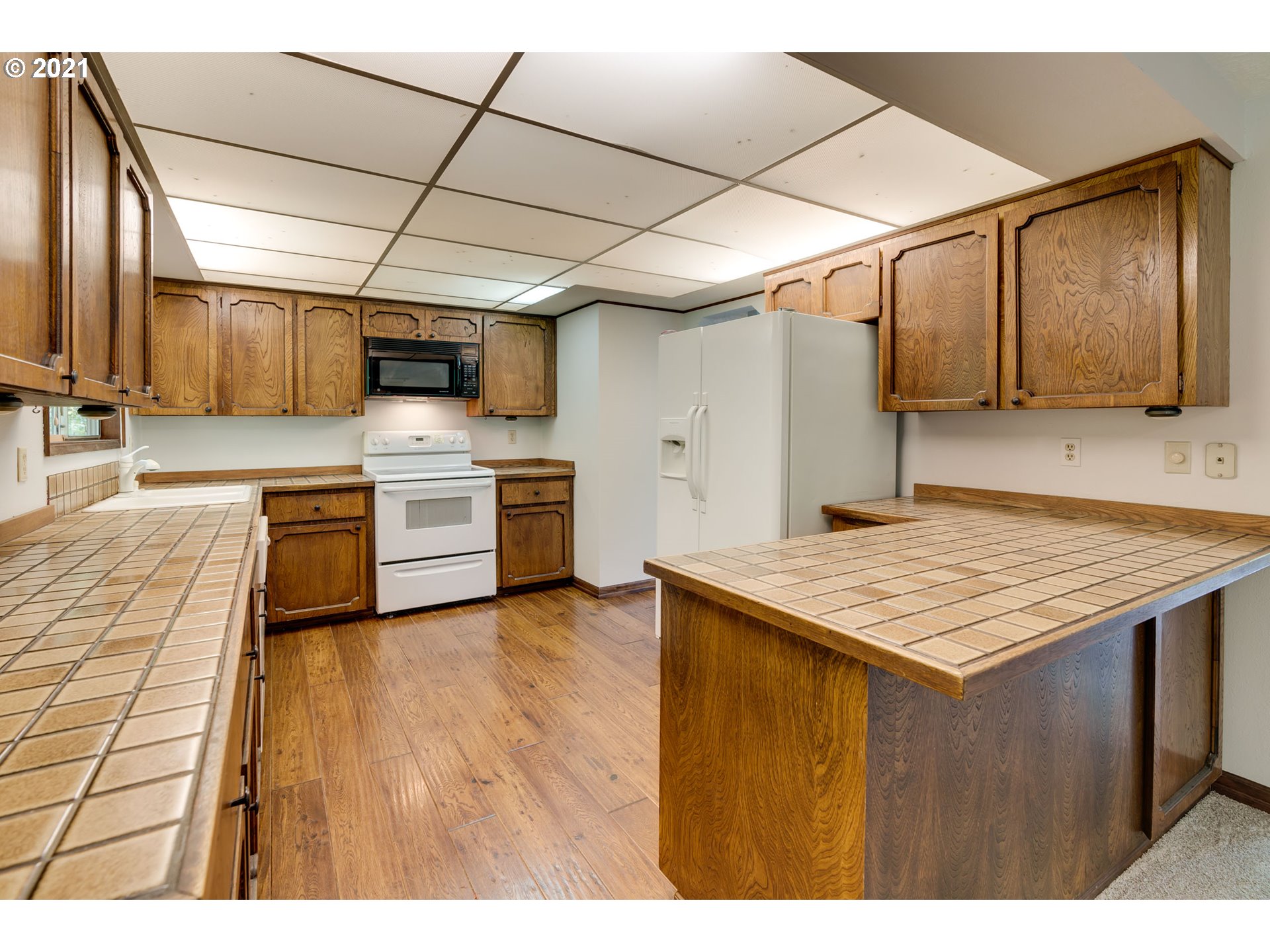 17201 Southeast Tong Road Damascus, OR 97089 - Photo 8 of 21 a kitchen with kitchen island a stove a sink and a refrigerator