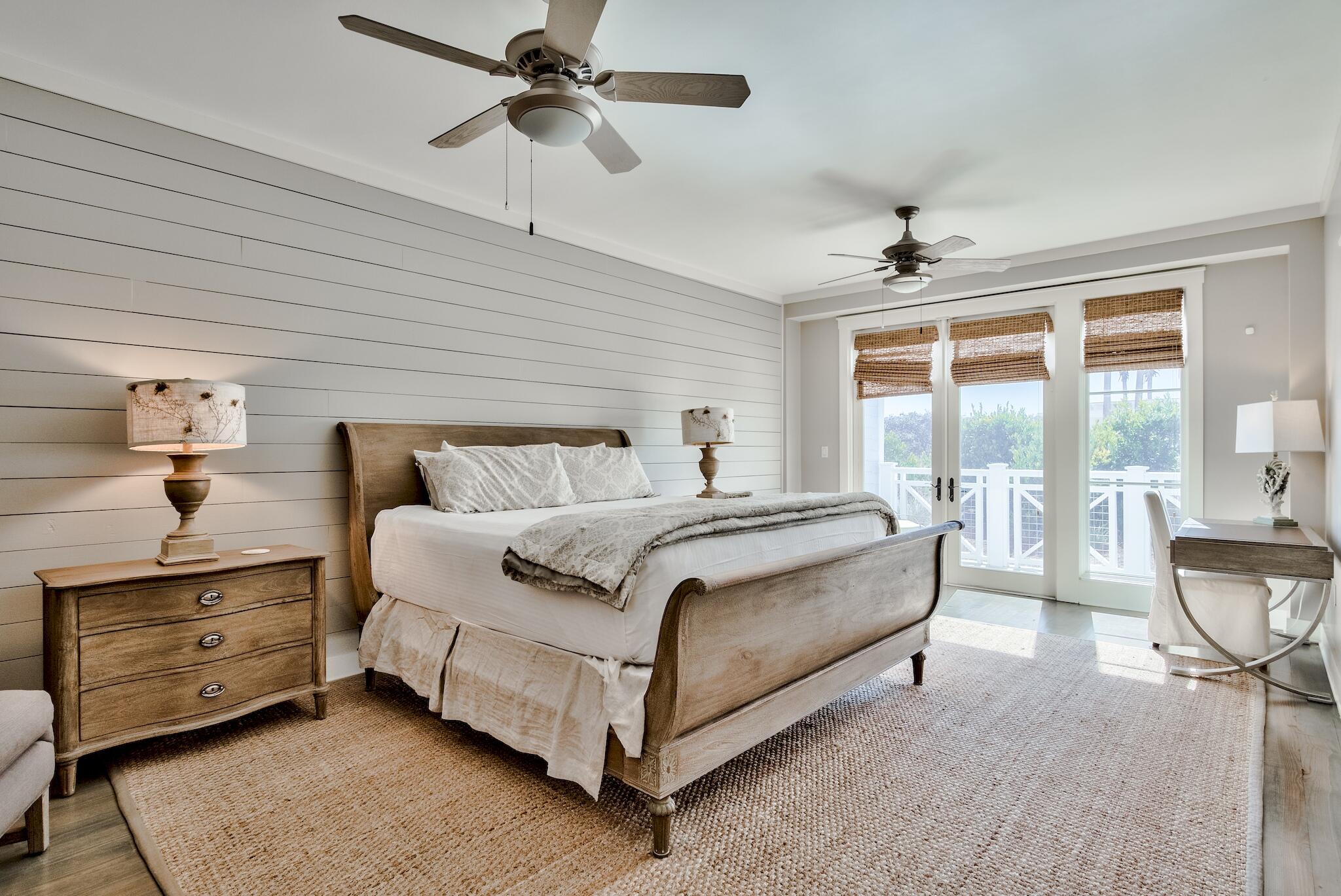 337 Bridge Lane, Unit B102 Watersound, FL 32461 - Photo 28 of 41 a spacious bedroom with a bed and wooden floor
