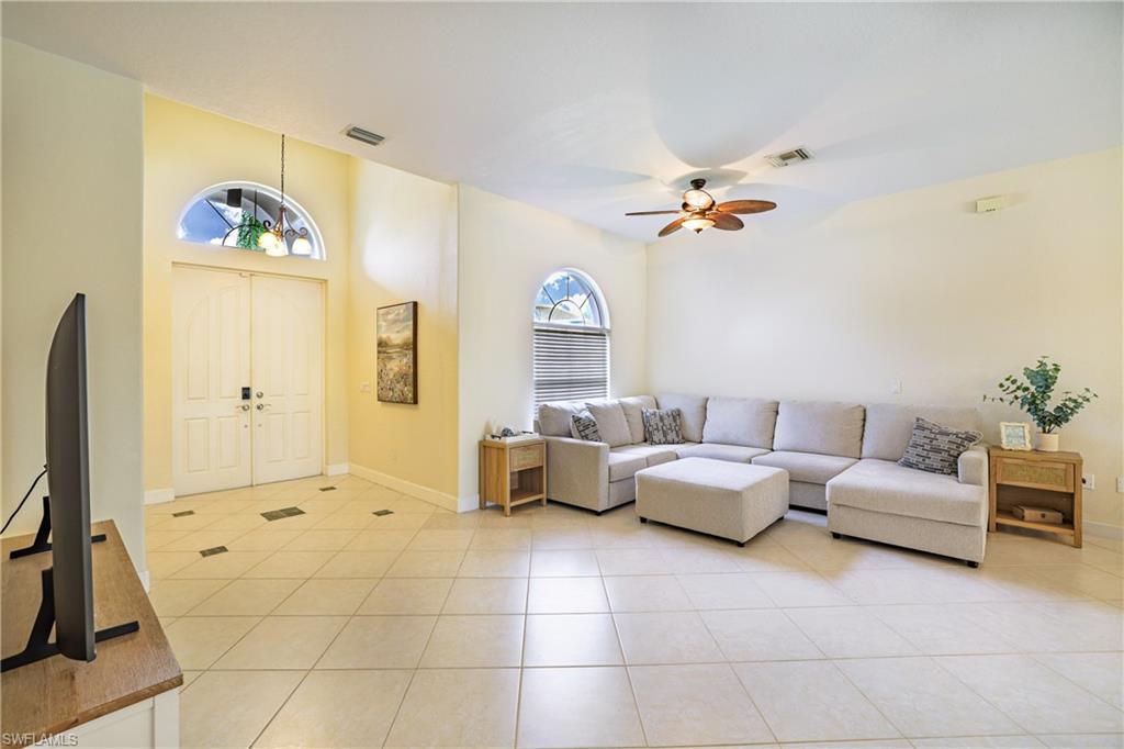 5235 Malvern Court Naples, FL 34112 - Photo 7 of 28 a living room with furniture a chandelier and a flat screen tv