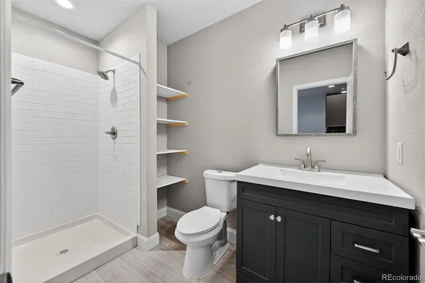 a bathroom with a sink a toilet and shower