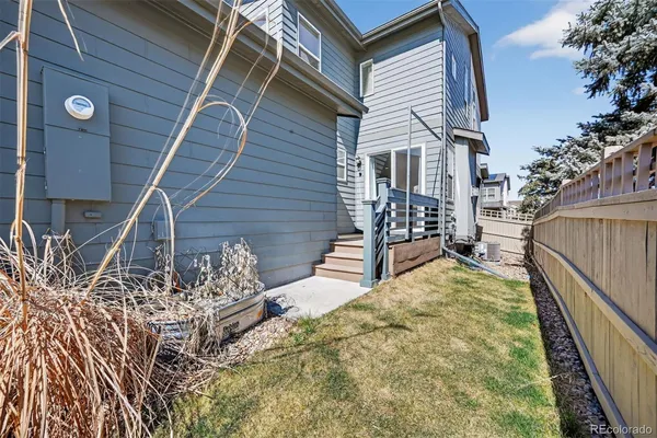 a view of house with wooden deck and furniture