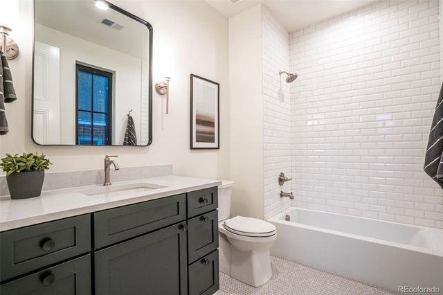 a bathroom with a double vanity sink toilet and shower