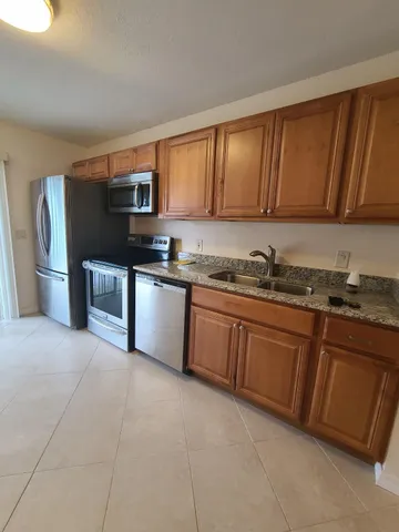 a kitchen with stainless steel appliances granite countertop a refrigerator and a stove top oven