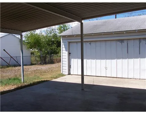 a backyard of a house with wooden floor and fence