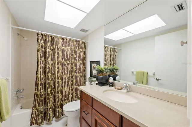 a bathroom with a sink a toilet and shower curtain