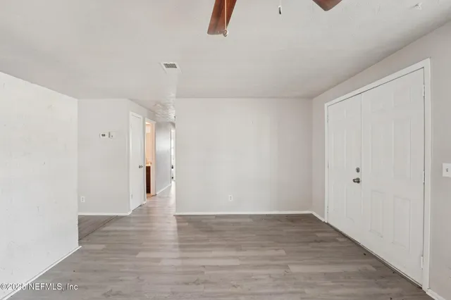 a view of an empty room with wooden floor