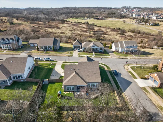 an aerial view of a house with a garden and lake view