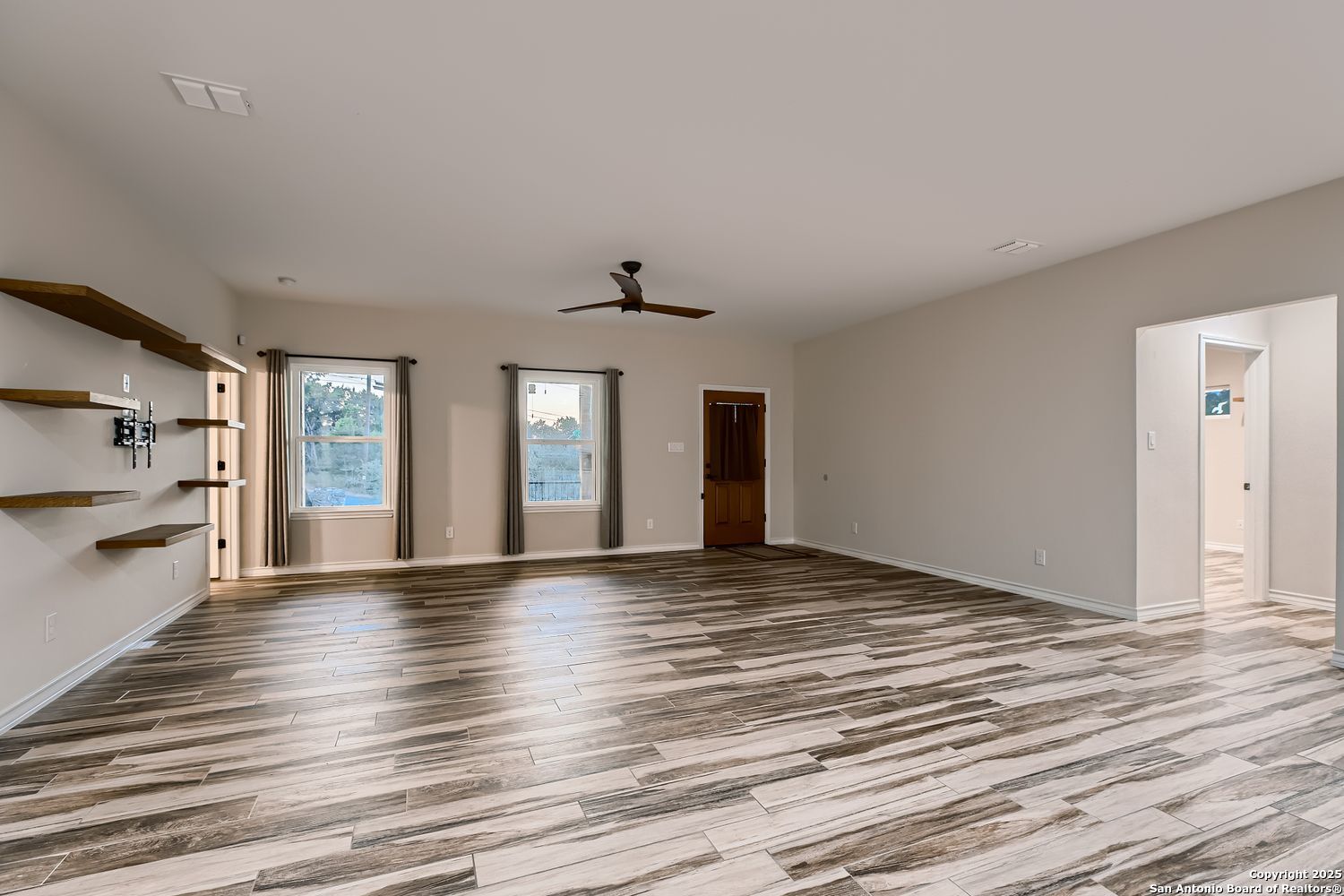 3963 Summit Hurst New Braunfels, TX 78132 - Photo 7 of 28 a view of an empty room with window and wooden floor