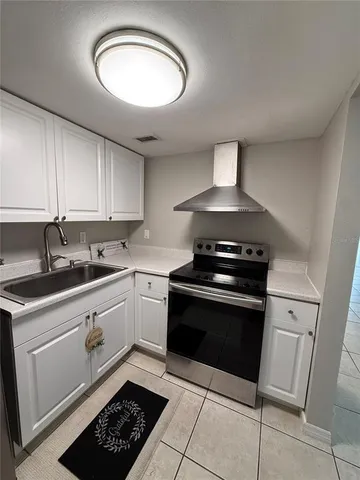 a kitchen with granite countertop a stove sink and cabinets
