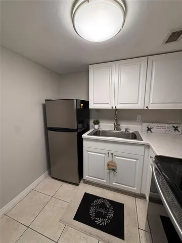 a kitchen with a sink a stove cabinets and a refrigerator