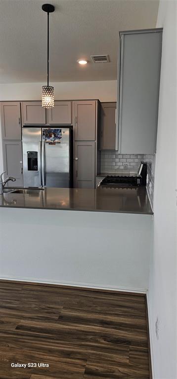 1401 Linwood Street Leander, TX 78641 - Photo 5 of 39 Kitchen featuring gray cabinetry, stainless steel fridge with ice dispenser, dark countertops, wood finished floors, and pendant lighting