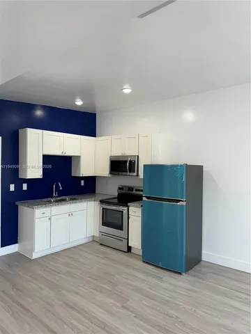 a kitchen with stainless steel appliances a refrigerator and a stove top oven