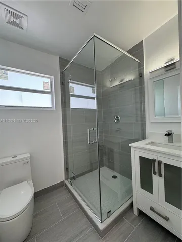 a bathroom with a shower a mirror and a sink