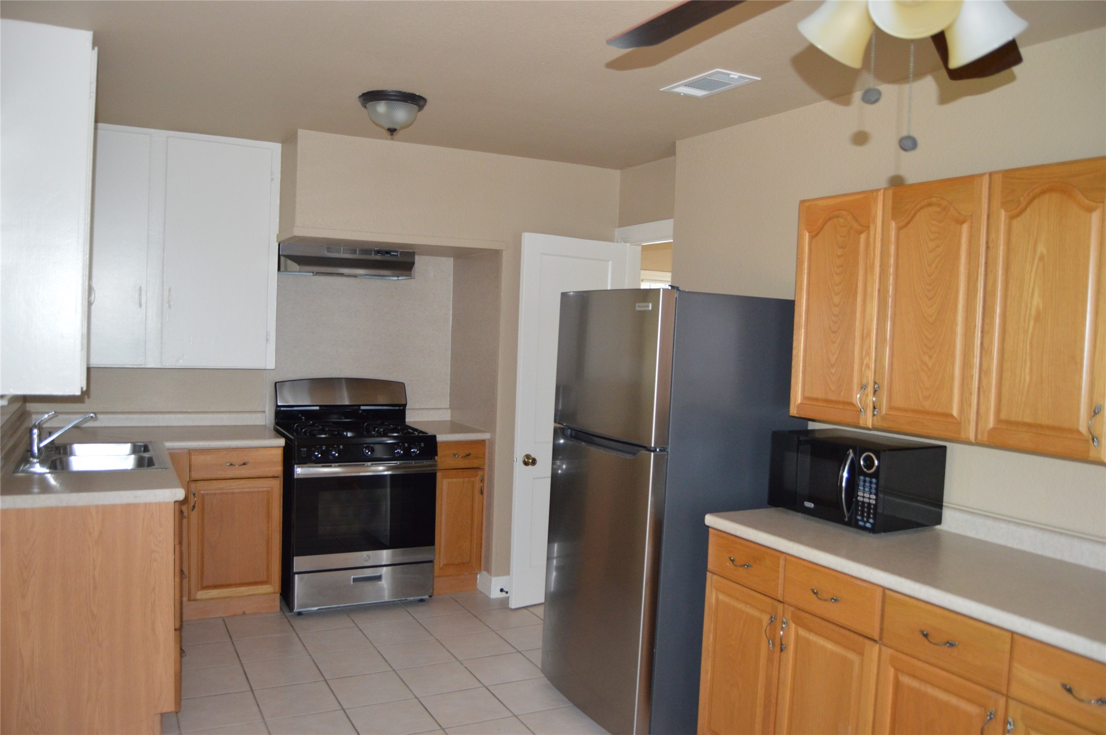 2616 East 3rd Street Austin, TX 78702 - Photo 9 of 11 a kitchen with stainless steel appliances a refrigerator stove and sink