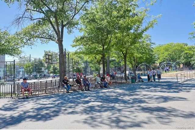 a couple of people sitting in a yard in front of a house