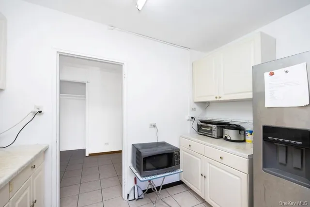 a kitchen with granite countertop white cabinets and white appliances