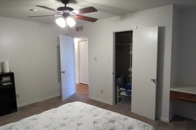 a view of a big room with closet and a chandelier fan