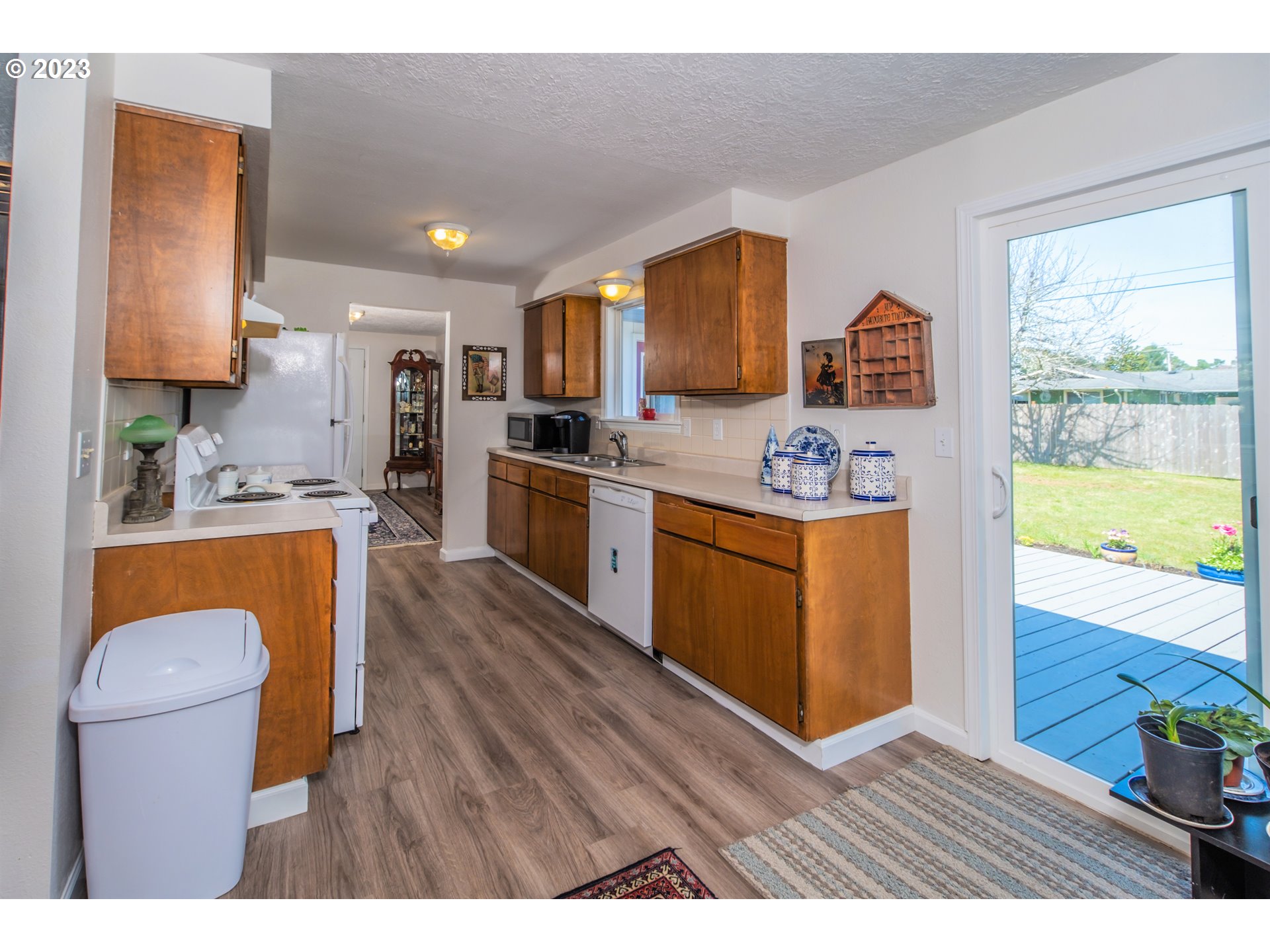 2035 16th Street Florence, OR 97439 - Photo 9 of 30 a kitchen with stainless steel appliances granite countertop a sink dishwasher a stove a refrigerator and a dining table with wooden floor