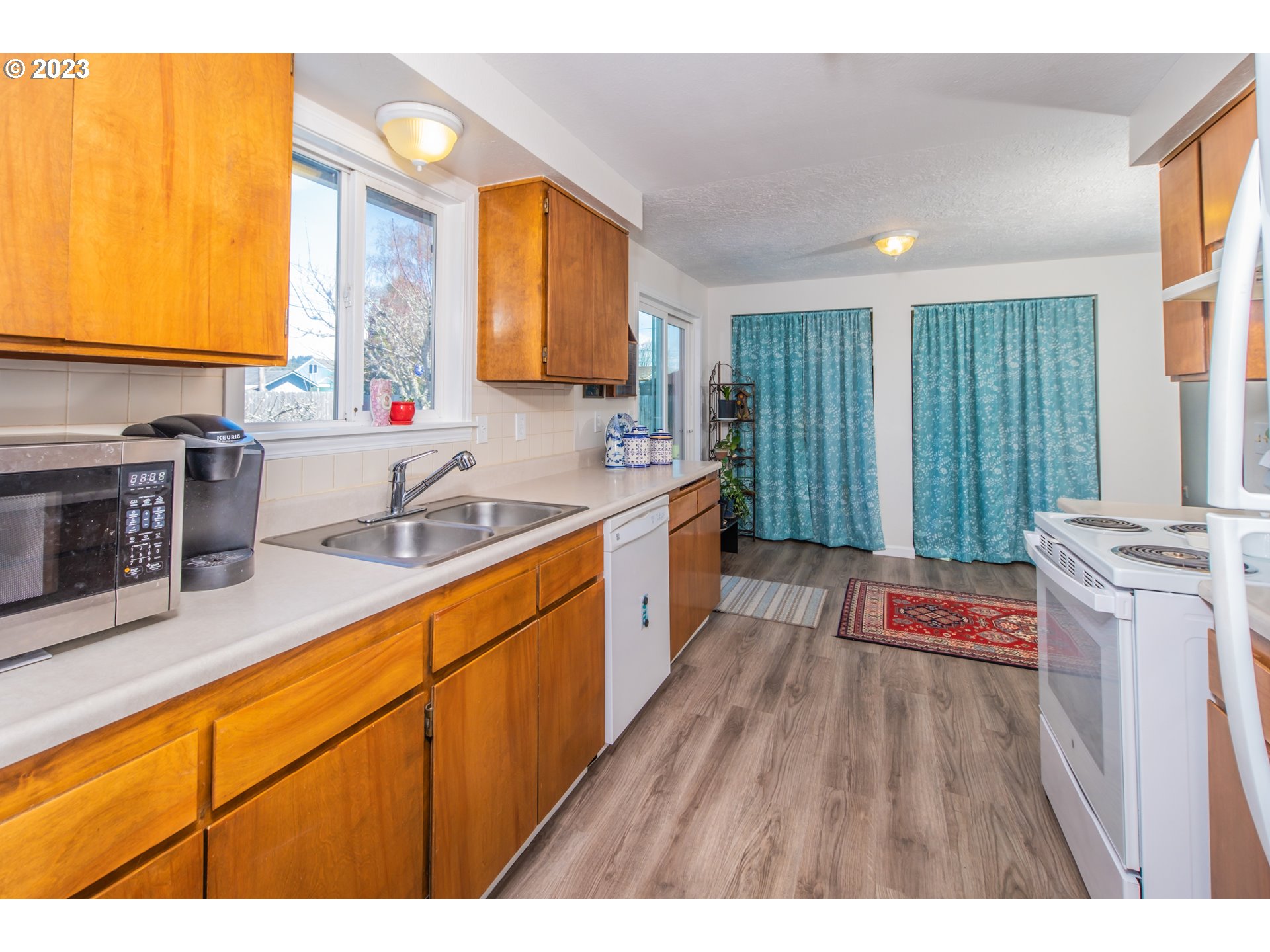 2035 16th Street Florence, OR 97439 - Photo 10 of 30 a kitchen with stainless steel appliances granite countertop a sink stove and refrigerator