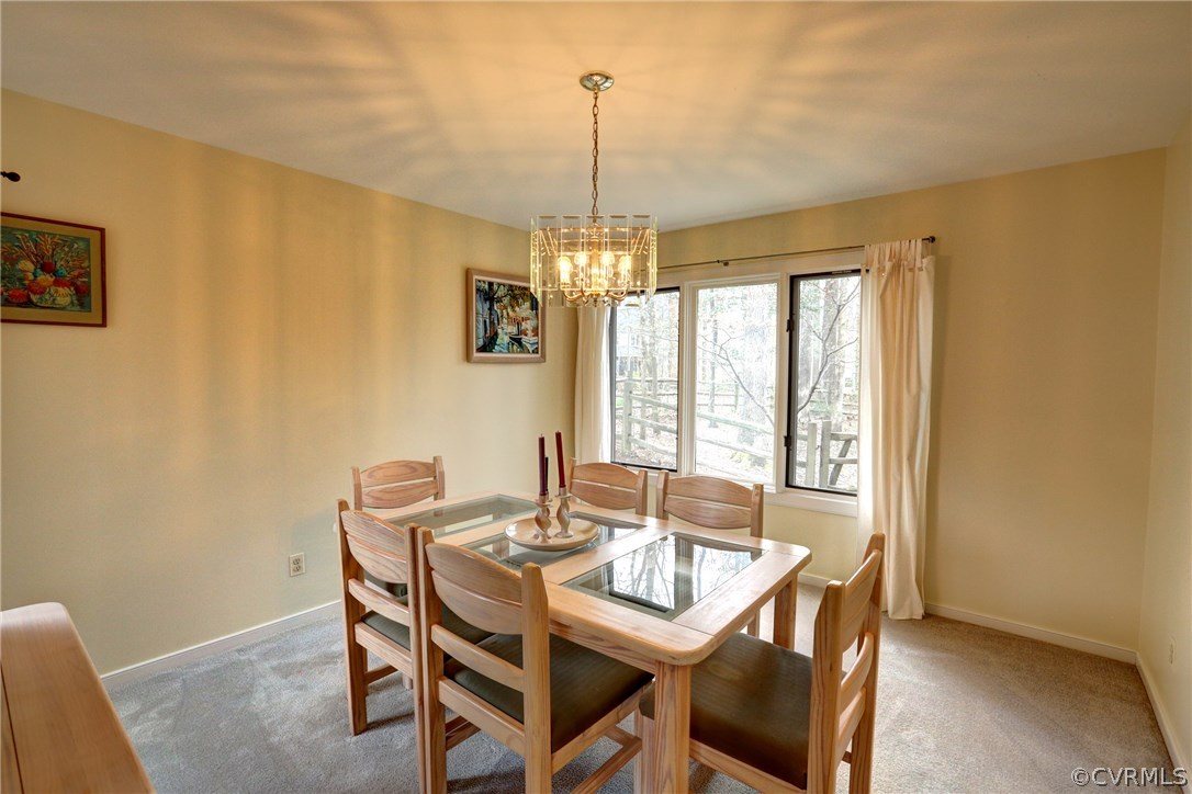 13708 Sandy Oak Road Chester, VA 23831 - Photo 7 of 32 a dining room with furniture a chandelier and window