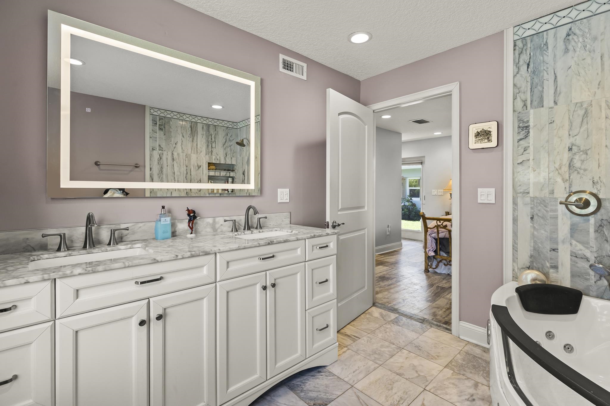7 16th Street St. Augustine, FL 32080 - Photo 9 of 61 a spacious bathroom with a granite countertop sink a toilet a mirror and shower