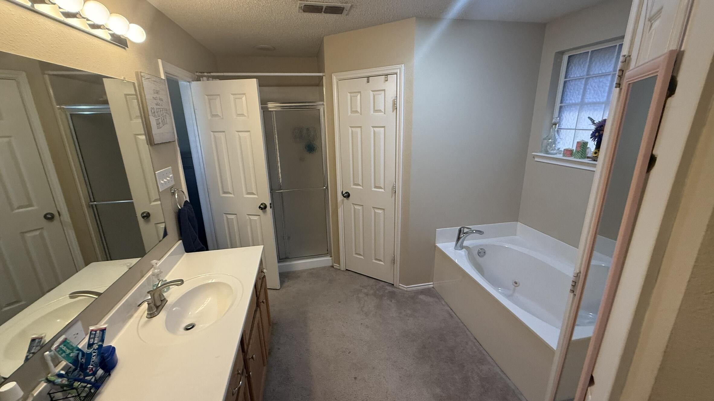 6808 84th Street Lubbock, TX 79424 - Photo 7 of 11 a bathroom with a tub sink and mirror