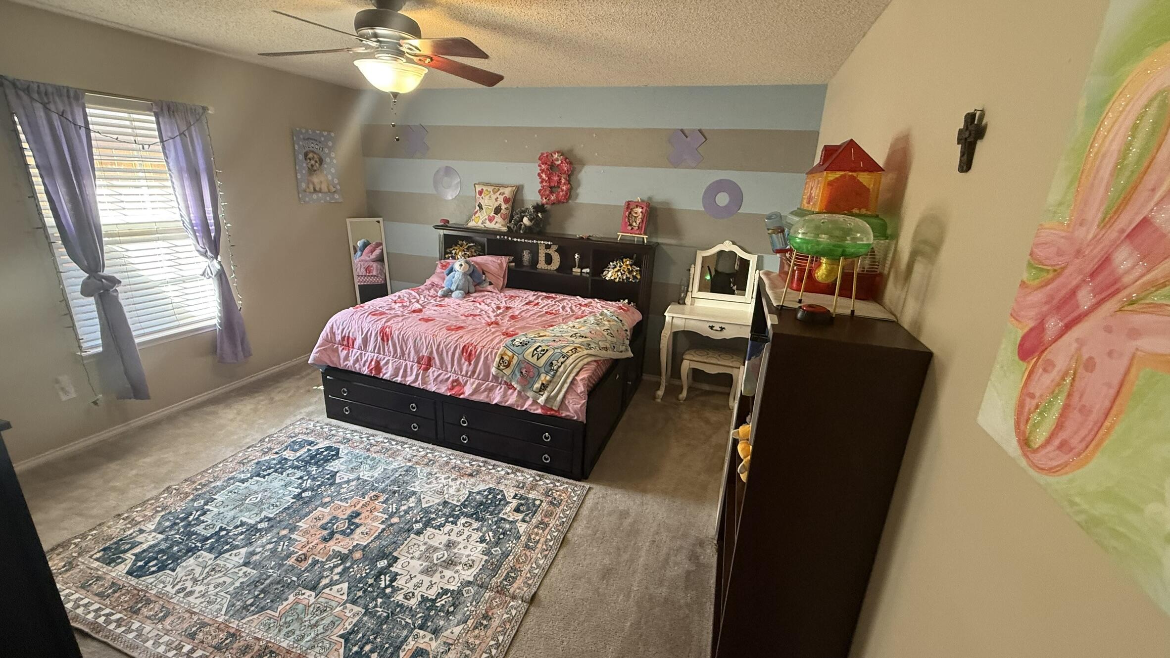 6808 84th Street Lubbock, TX 79424 - Photo 9 of 11 a bedroom with a bed and a mirror on the dresser