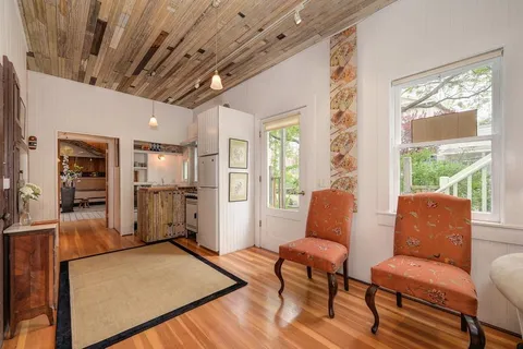 a living room with furniture wooden floor and a large window