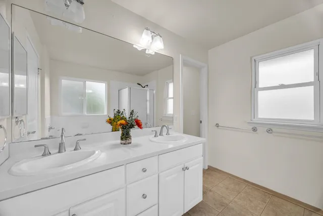 a bathroom with double vanity and a mirror