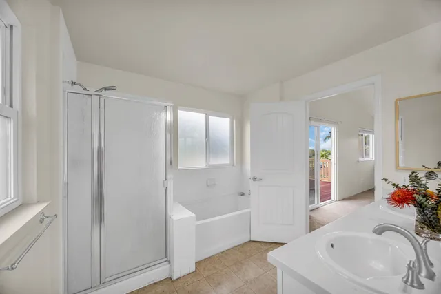 a bathroom with a tub a sink and a large mirror